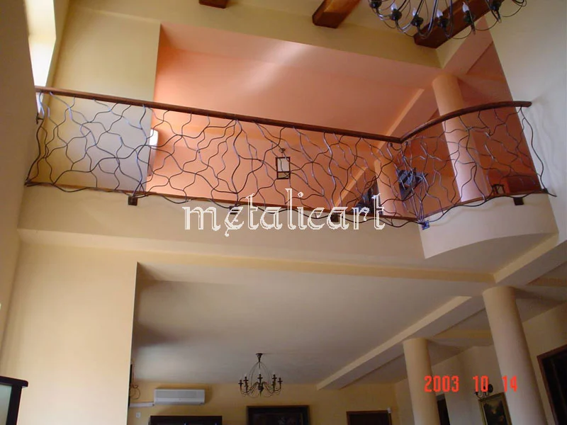 Balustradă de balcon interior cu desen liber, în linii subțiri, deasupra holului.