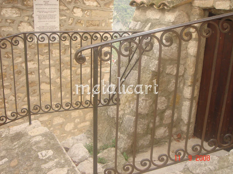 Balustradă exterioară cu volute mici repetate, montată pe o scară de piatră.