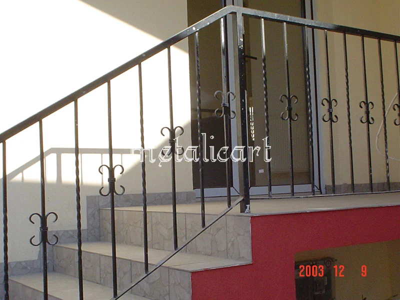 Balustradă cu bare drepte și ornamente mici în formă de fluture, în finisaj închis.