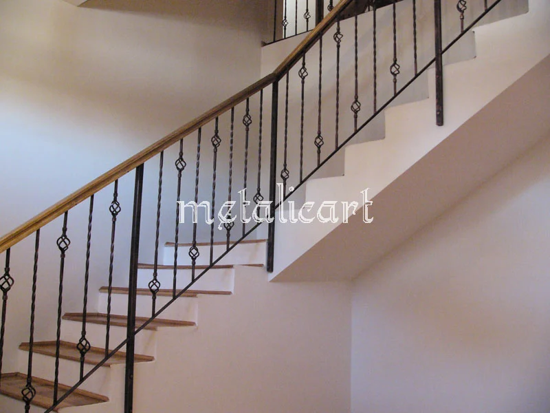 Balustradă cu bare răsucite și mici romburi forjate, urmând scara dreaptă.