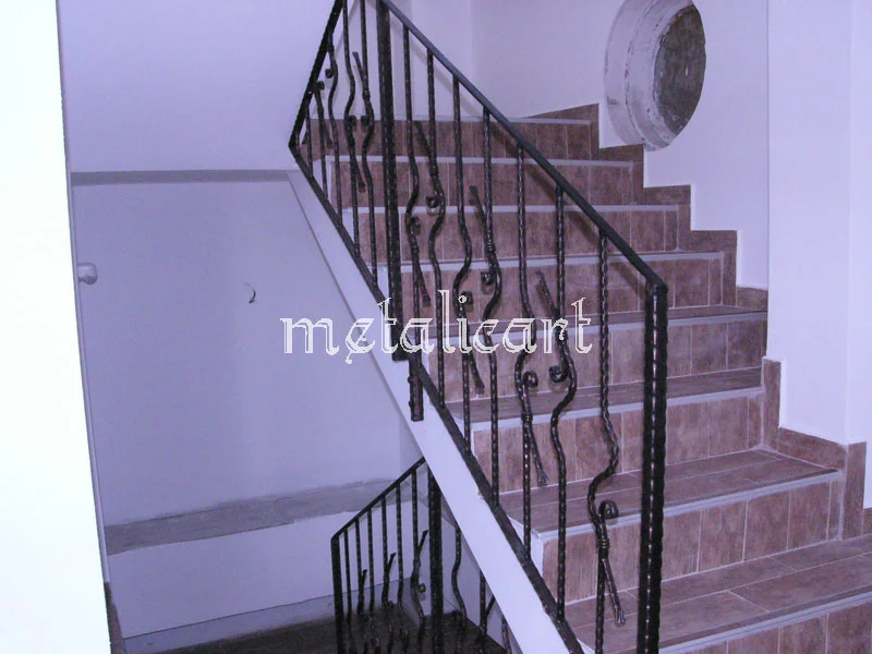 Balustradă de scară cu bare ondulate și mână curentă continuă, în finisaj negru.