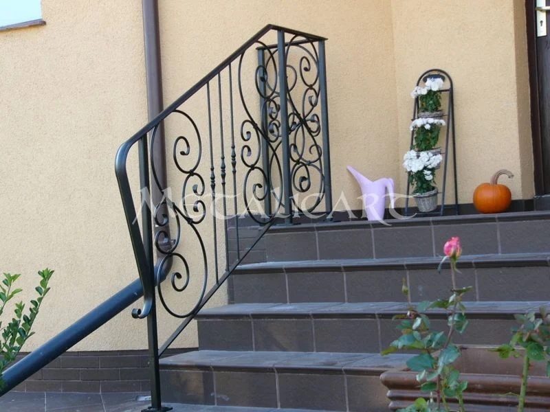 Balustradă exterioară de acces, cu panou de volute și mână curentă curbată, pe trepte de piatră.