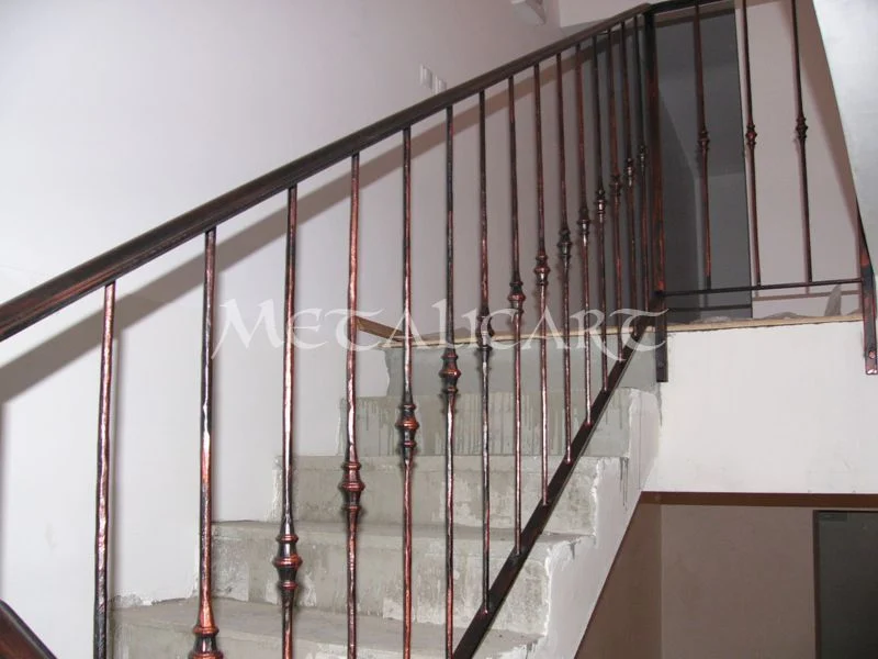 Balustradă de scară cu bare profilate și noduri, finisaj brun-roșcat.