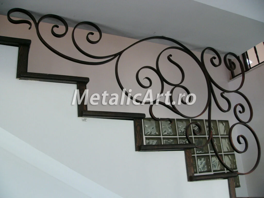 Balustradă-parapet montată pe perete, cu volute libere care urmează treptele.