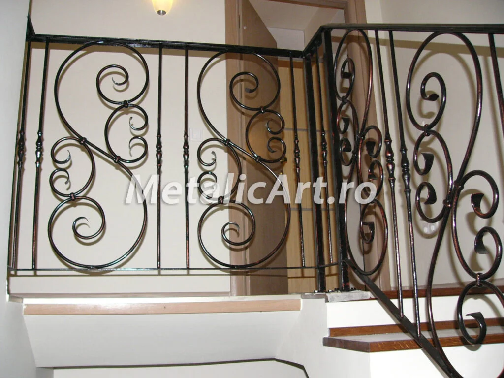 Balustradă de palier cu volute mari în panouri, sub mână curentă continuă.