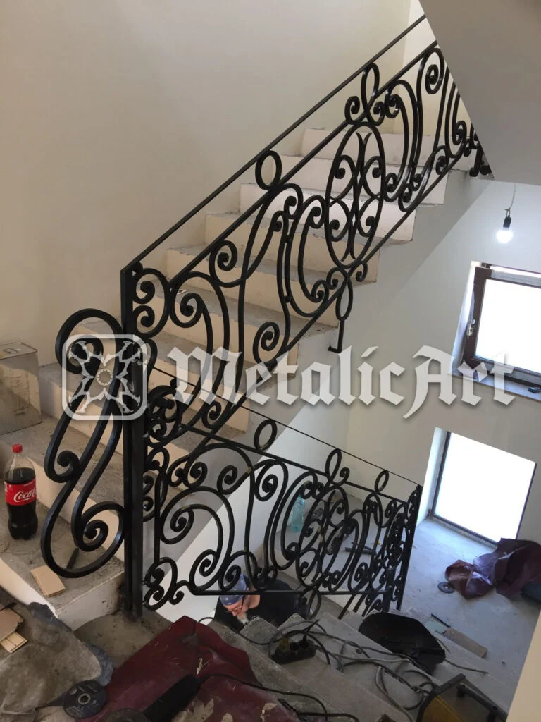 Balustradă de scară cu volute simetrice și rozete, montată pe două rampe.
