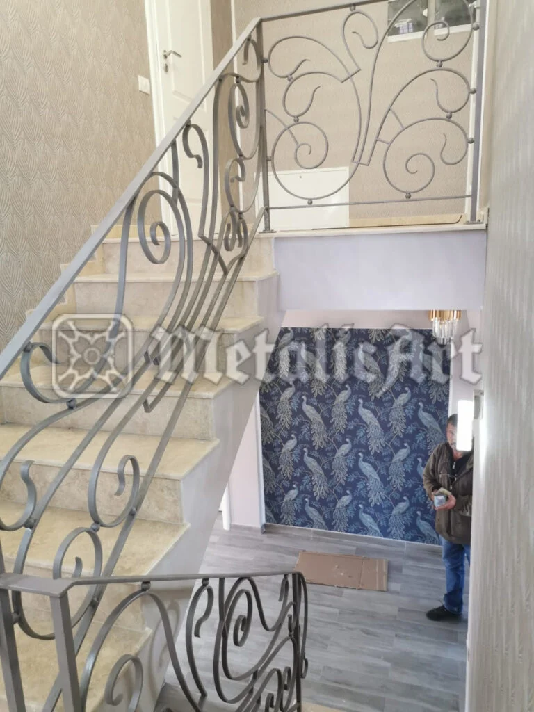 Balustradă de scară și palier, cu panouri de volute simetrice, finisaj deschis.