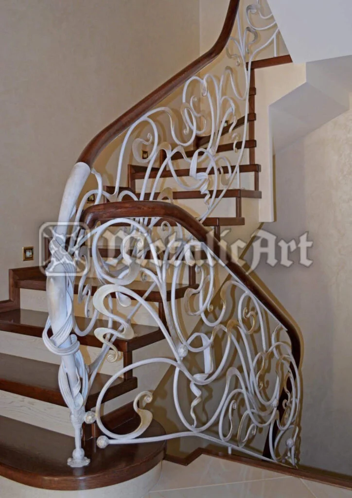 Balustradă albă cu volute ample, sub mână curentă din lemn masiv, pe scară curbată.