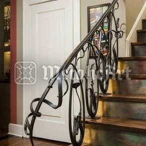 Balustradă interioară cu volute ample și mână curentă continuă, lângă o ușă albă.