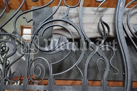 Detaliu de balustradă cu tije curbate și frunze alungite, forjate manual.