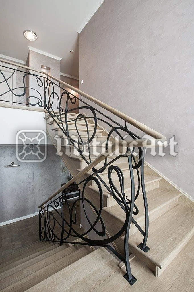 Balustradă interioară cu bucle mari, deschise, care urmează rampa scării și paliera.