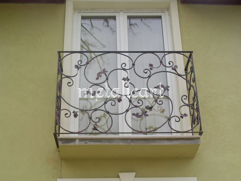 Balustradă mică de fereastră, cu vrejuri, frunze și flori forjate.