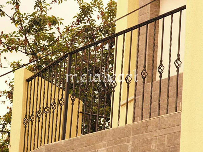 Balustradă de balcon și scară exterioară, cu bare răsucite și coșulețe forjate.