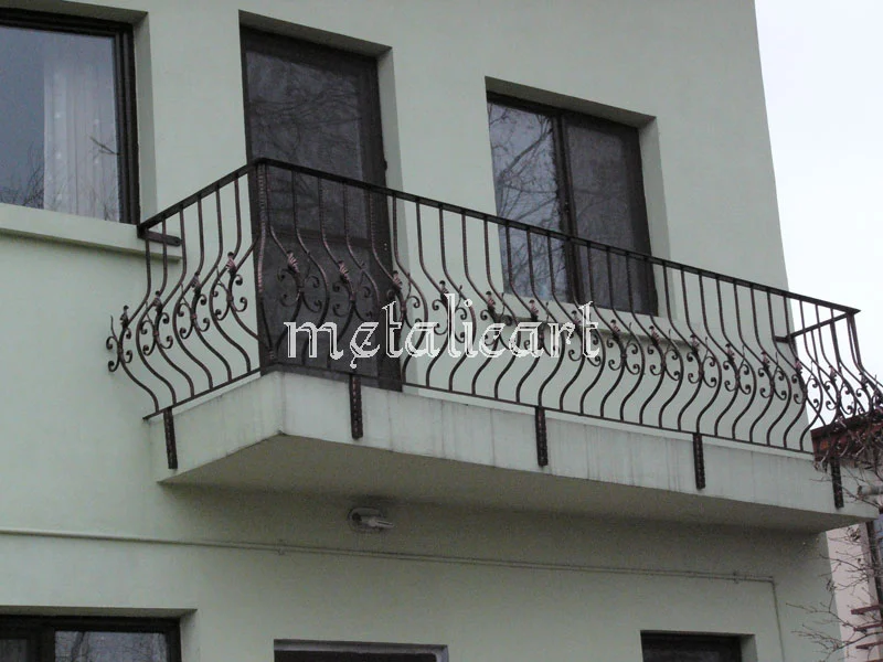 Balustradă bombată de balcon, cu bare curbate și volute la capete.