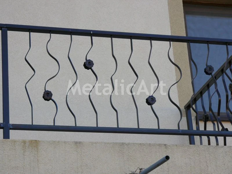 Balustradă de balcon cu bare ondulate și rozete forjate.