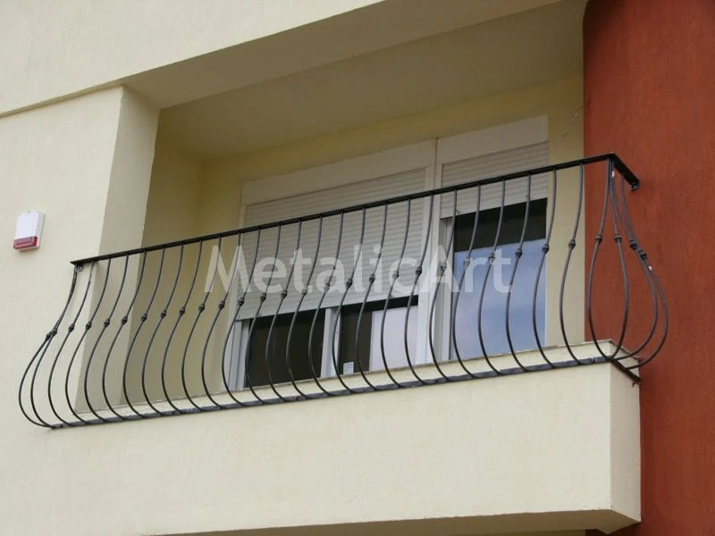 Balustradă bombată de balcon, cu bare curbate și noduri forjate.
