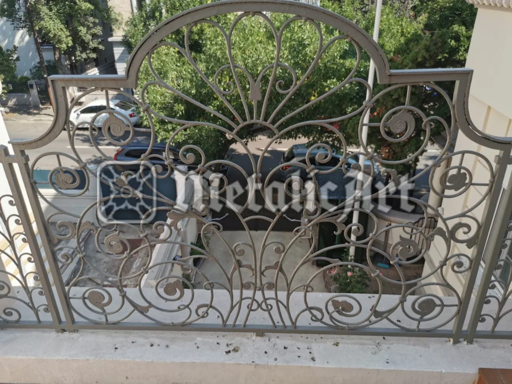 Balustradă de balcon cu evantai central, volute și spirale, în finisaj deschis.