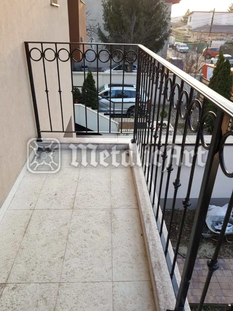 Balustradă de terasă cu bare verticale, noduri și friză de cercuri.