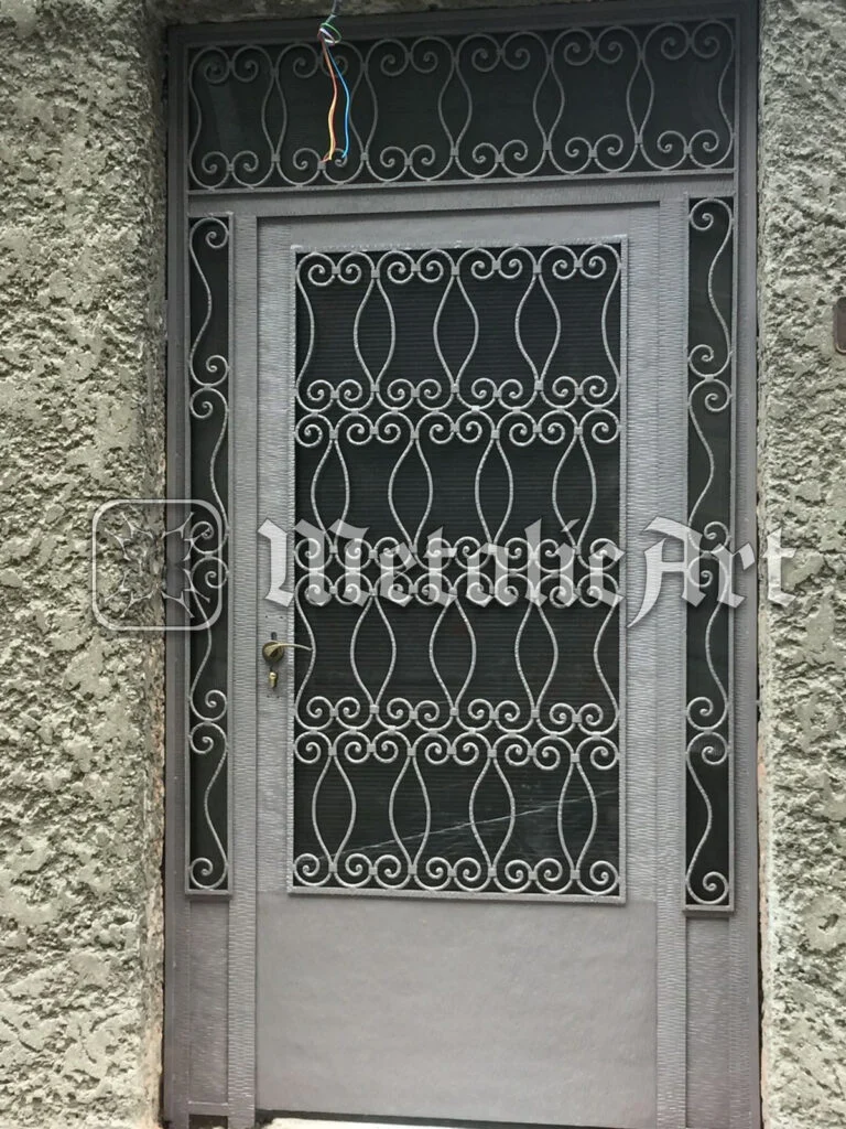 Ușă metalică cu panou de grilaj din volute mărunte și supralumină asortată.