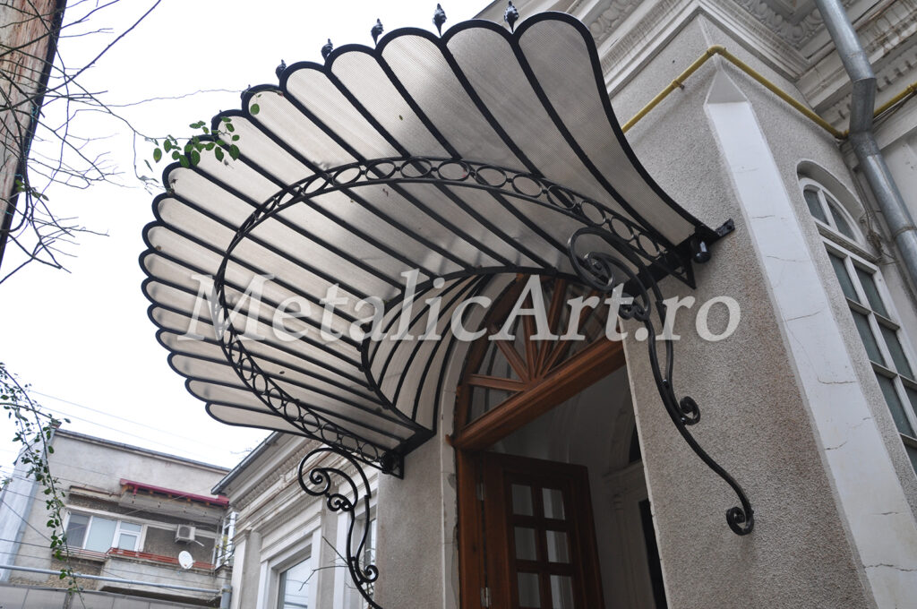 Copertină în formă de evantai, cu nervuri forjate radiale și margine festonată.