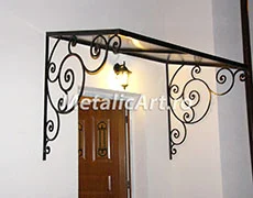 Copertină dreaptă cu console simetrice de volute, peste ușa de lemn.