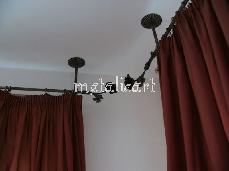 Galerie de perdea forjată, prinsă în tavan, cu suporturi decorative și perdele grena.