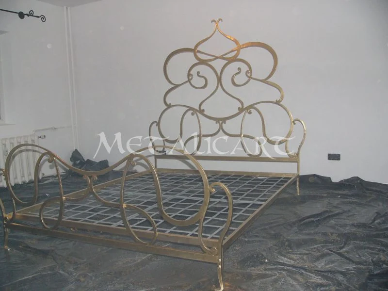 Pat forjat cu tăblie din volute și finisaj auriu, montat în atelier.