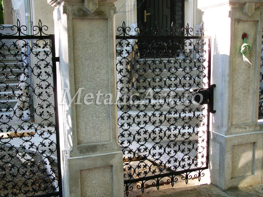 Poartă pietonală și panouri de gard cu decor dens de crini forjați.
