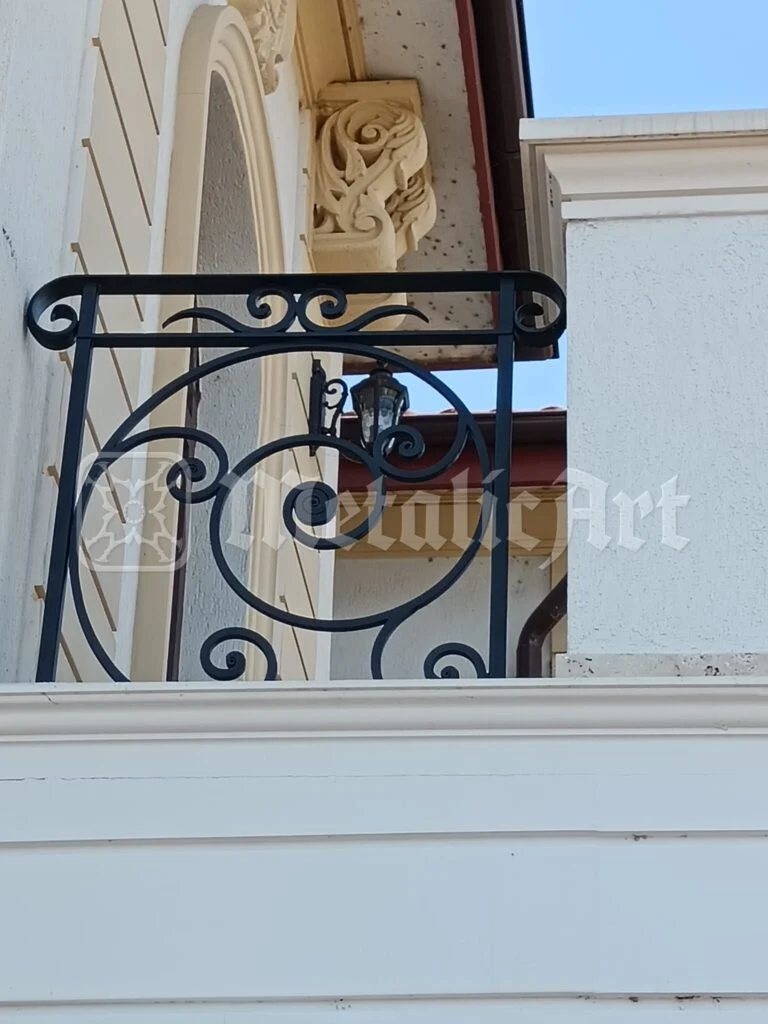 Panoul balustradei văzut de jos, pe fațada cu consolă sculptată.