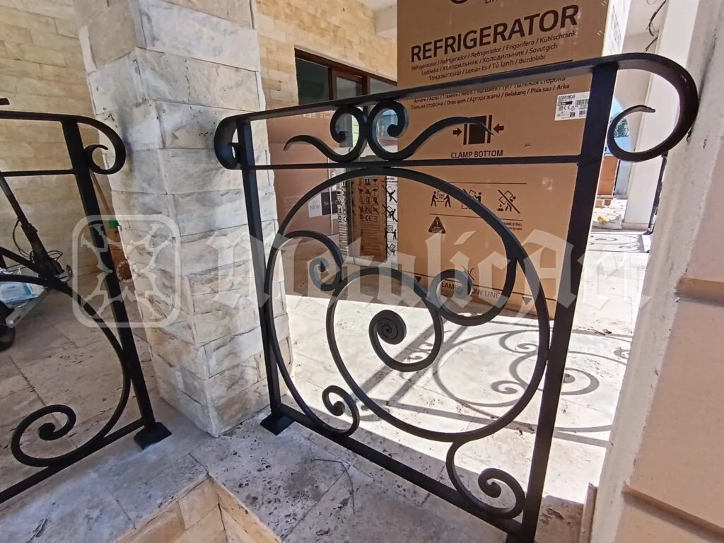 Panou de balustradă cu volută mare, lângă stâlpul de piatră, în timpul finisajelor.