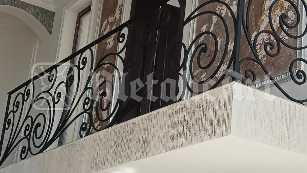 Balustrada balconului interior, pe toată lungimea, cu volute dese.