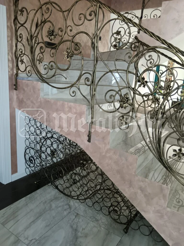 Balustrada văzută de jos, cu florile forjate pe peretele roz.