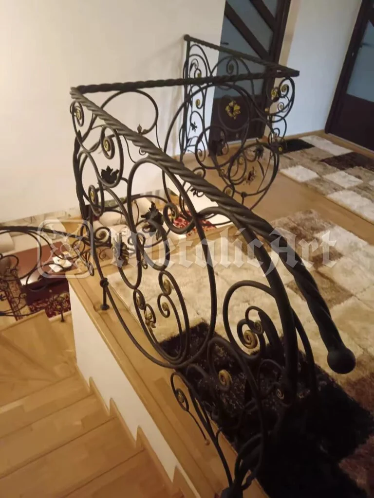 Capătul mâinii curente, răsucit în volută, deasupra parchetului.