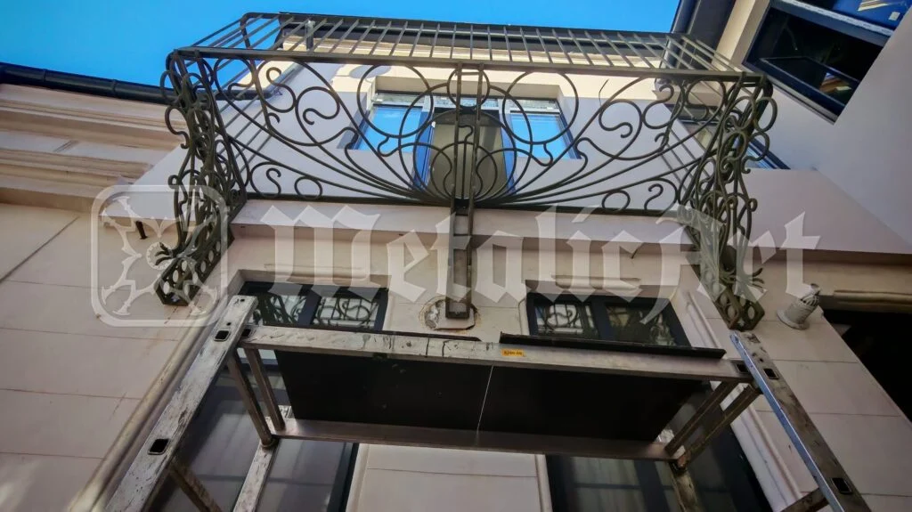 Balconul cu linii unduite, văzut de jos, pe cerul albastru.
