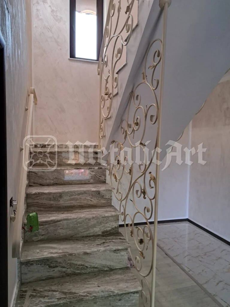 Scara care urcă, cu balustrada în dreapta și fereastra deasupra.
