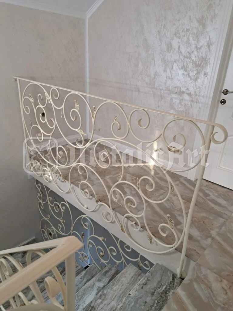 Balustrada podestului de sus, lângă ușa albă.