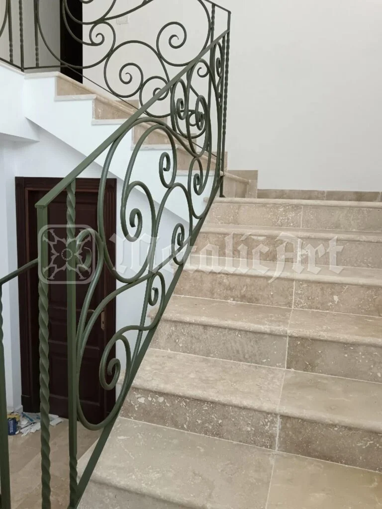 Rampa de sus a scării, cu mâna curentă urcând spre etaj.