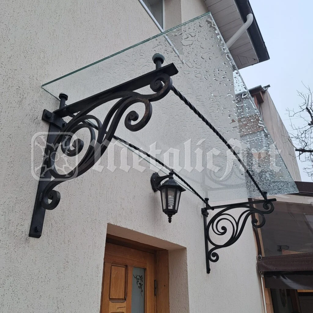 Marchiză din sticlă pe console din fier forjat, deasupra ușii de intrare