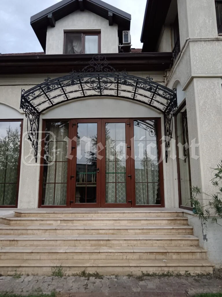 Intrarea întreagă, cu copertina deasupra treptelor de travertin.