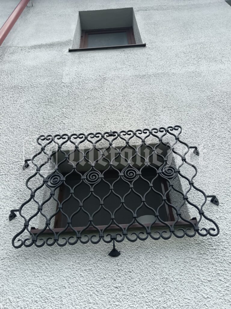 Grilajul ferestrei de la parter, sub fereastra mică a podului.