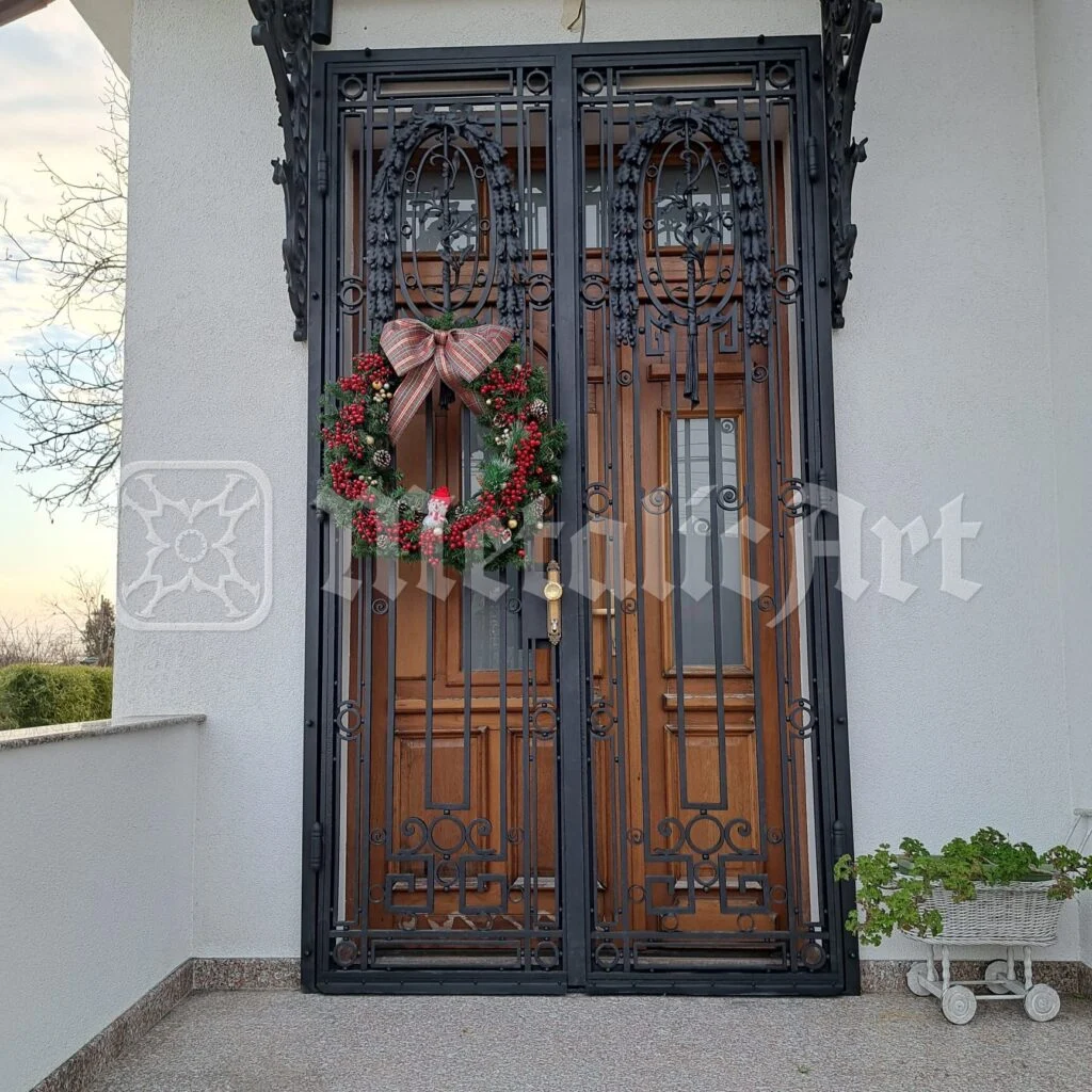 Grilajul ușii în lumina serii, cu grădina în spate.
