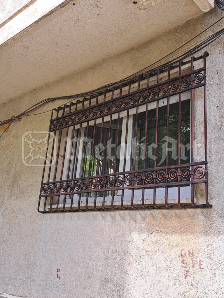 Grilajul ferestrei, cu vârfurile de jos sprijinite pe tencuială.