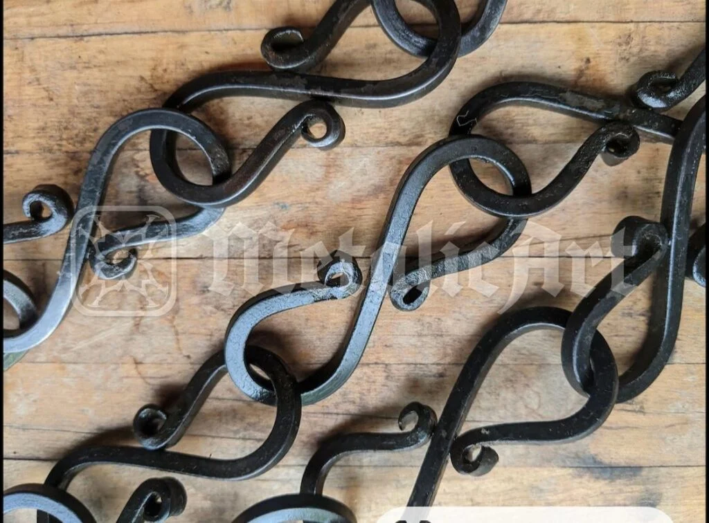 Panou decorativ din fier forjat, cu volute, pe fundal de lemn