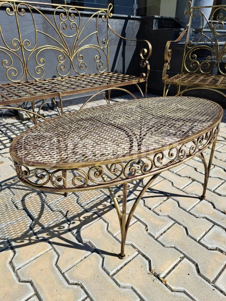 Masa ovală cu blat împletit și volutele de pe margine.