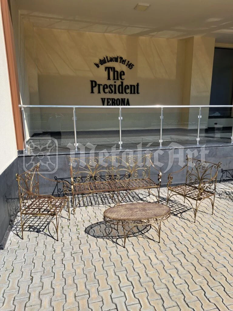 Mobilierul de grădină așezat în fața intrării, cu masa ovală la mijloc.