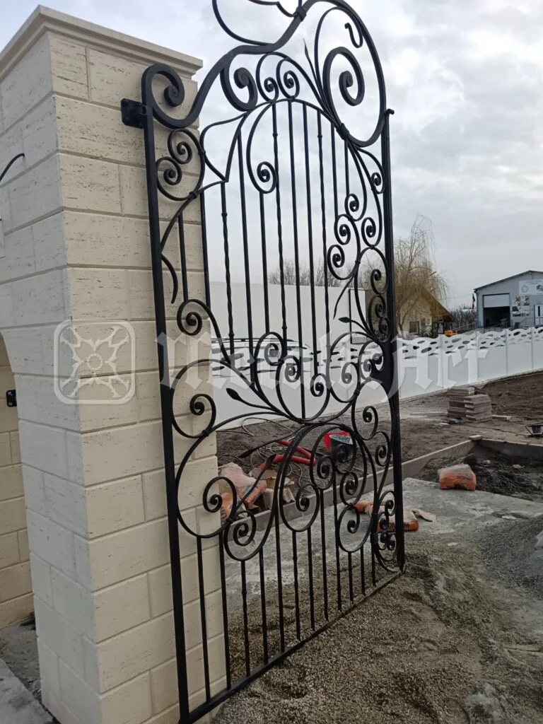Canatul înalt al porții, lângă stâlpul de piatră, văzut de jos.