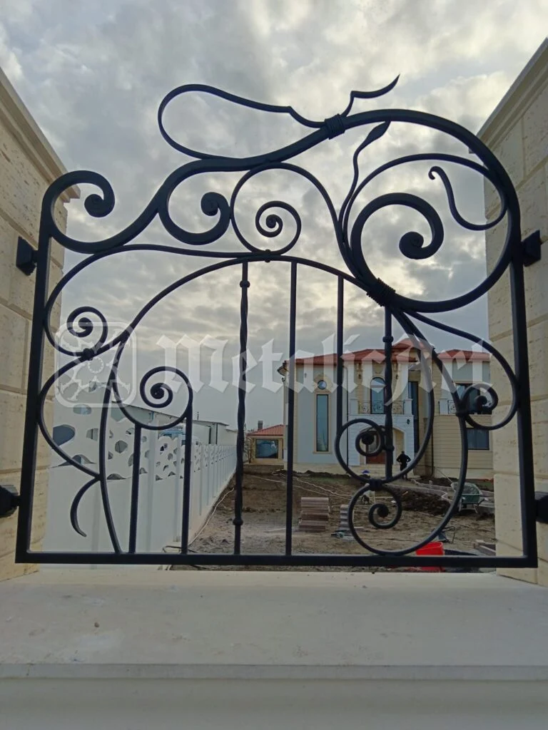 Canatul porții, văzut din curte, cu casa în construcție în spate.