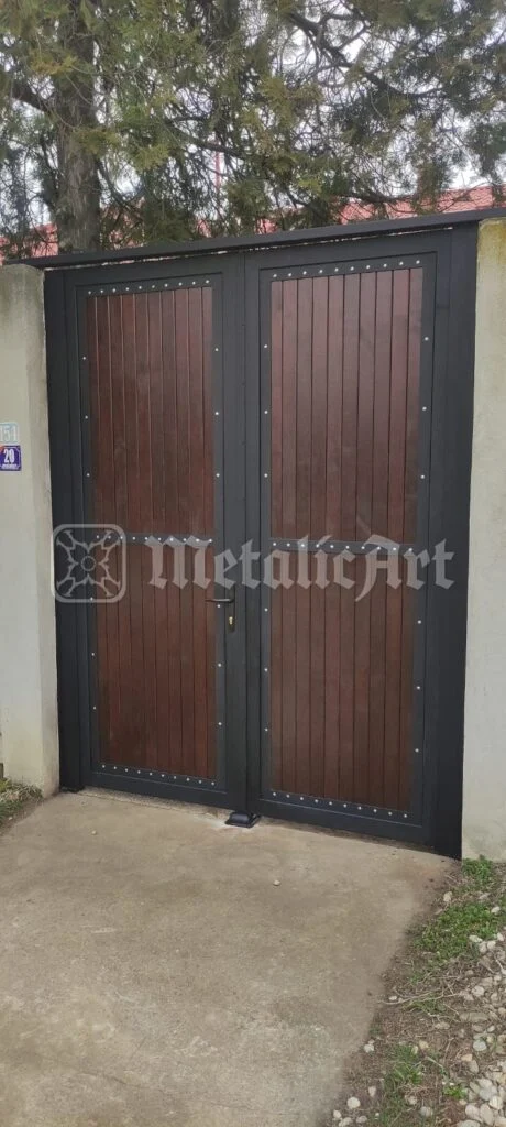 Poarta închisă, văzută din față, cu copacul în spate.