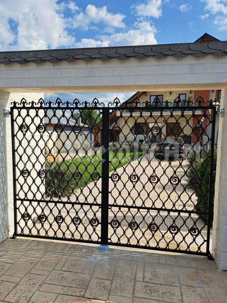Poarta auto închisă, văzută din curte, cu casa în spate.