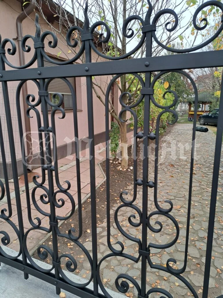 Coama porții, cu volutele mari, văzută din curte.